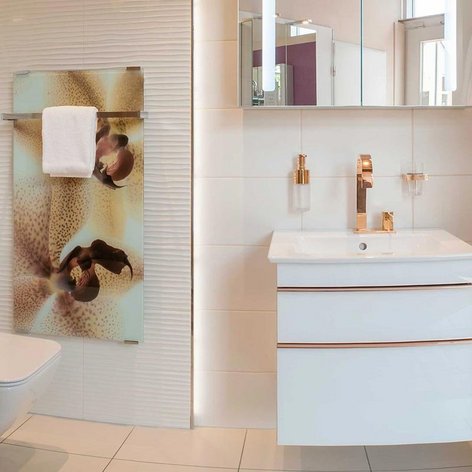 Ein modernes Badezimmer mit eleganten weißen Fliesen, einem stilvollen Waschbecken und goldenen Armaturen, die Luxus ausstrahlen.