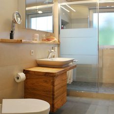 Das Badezimmer zeigt eine Dusche mit Glasabtrennung und eine stilvolle Holzkommode, die für Stauraum sorgt.