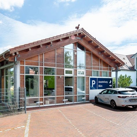 Die Fassade eines Unternehmensgebäudes mit einem klaren blauen Himmel und einer einladenden Atmosphäre, ideal für Kundenbesuche.
