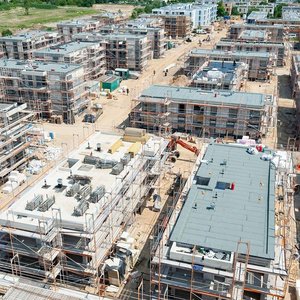 Luftaufnahme einer lebhaften Baustelle mit Wohngebäuden Blick auf eine große Wohnbaustelle mit zahlreichen unvollendeten Gebäuden, die von Baugerüsten umgeben sind.