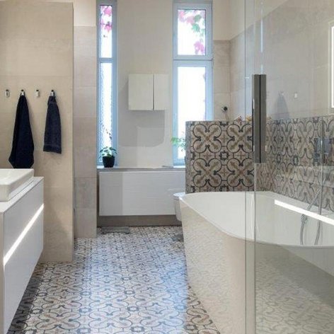 Ein modernes Badezimmer mit eleganter Badewanne, stilvollen Fliesen und großen Fenstern, die natürliches Licht hereinlassen.