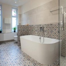 Ein modernes Badezimmer mit einer freistehenden Badewanne und eleganten Fliesen, die eine stilvolle Atmosphäre schaffen.