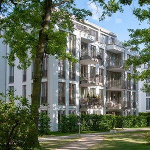 Harmonische Architektur in einer ruhigen Parklandschaft Ein ruhiger Park mit gepflegten Rasenflächen, Bänken und hohen Bäumen, die Schatten spenden und eine entspannte Atmosphäre schaffen.