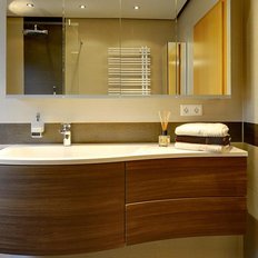 Das Badezimmer zeigt eine stilvolle Kombination aus Holz- und Fliesendesign, ergänzt durch frische Handtücher und dekorative Elemente.