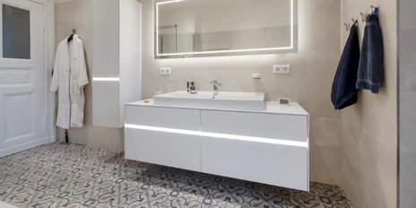 Ein helles Badezimmer mit einem minimalistischen Waschtisch, dekorativen Accessoires und einem einladenden Ambiente.