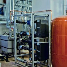 Komplexe Rohrleitungen und Maschinen in einem technischen Raum, der für die Wasser- oder Heizungsversorgung genutzt wird.