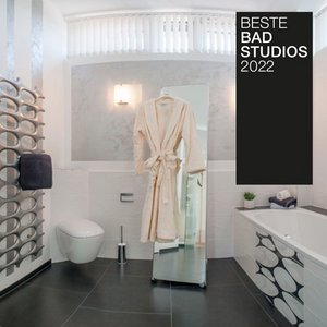 Ein modernes Badezimmer mit eleganter Badewanne, einem großen Spiegel und einem flauschigen Bademantel, der an einem Haken hängt.