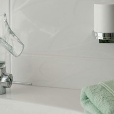 Ein eleganter Wasserhahn mit einer einzigartigen Glasform, umgeben von einem frischen Handtuch und einem Seifenstück.