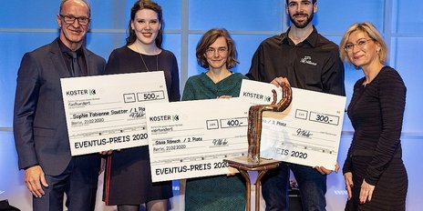 Fünf Personen stehen auf einer Bühne und halten große Schecks für den EVENTUS-PREIS 2020 in Berlin.